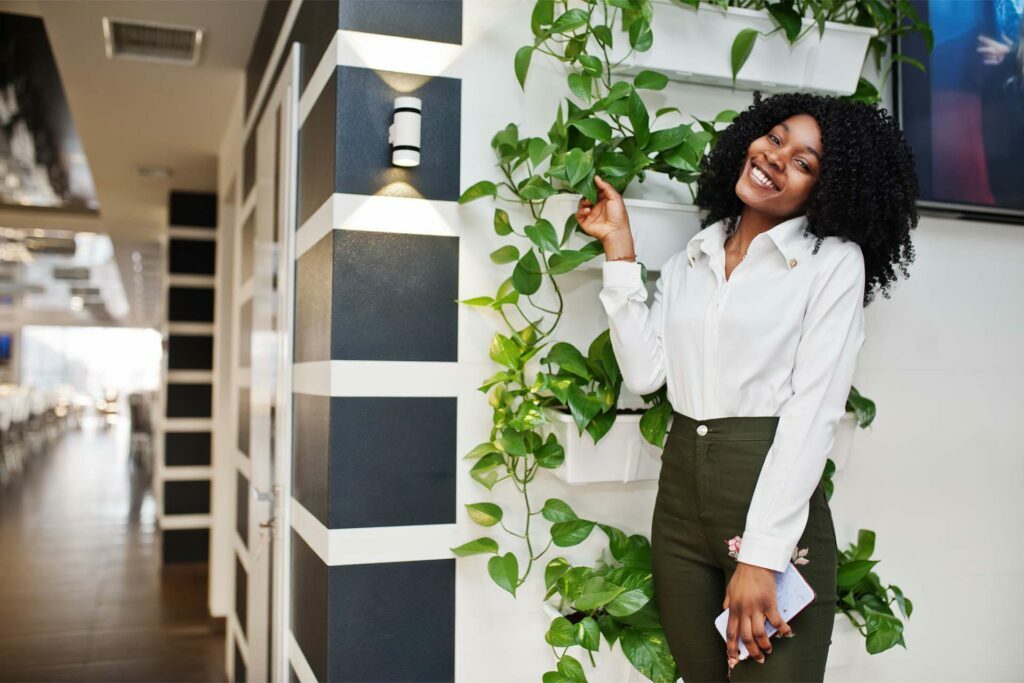 sheerful business african american lady with afro hair wear white blouse green pants posed cafe with mobile phone hand opt